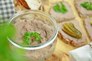 Vegane Leberwurst in Glas und auf Brot angerichtet