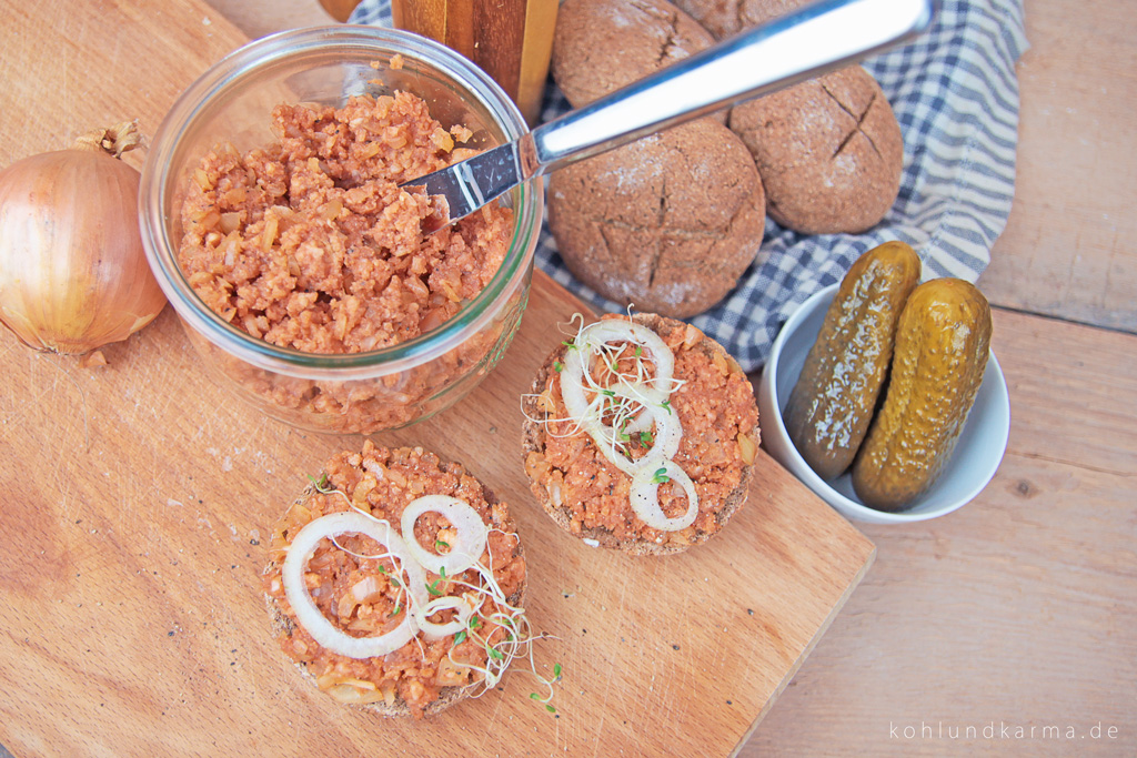 Veganes Mett auf Brötchen mit Brettchen angerichtet